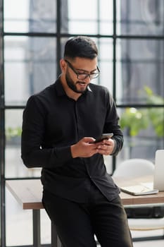 Young casual Businessman holding and using smartphone for sms messages