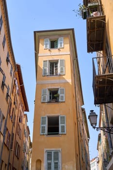 Old Town of Nice, France, narrow apartment building with shuttered windows and street in historical district Vieille Ville