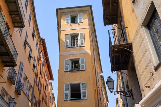 Old Town of Nice, France, narrow apartment building with shuttered windows and street in historical district Vieille Ville