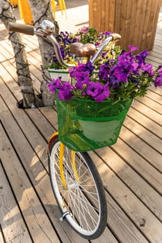 yellow ladies vintage bicycle with flower boxes for decorating streets and outdoor cafes. women's bicycle with floral decor or an old bicycle with flower boxes