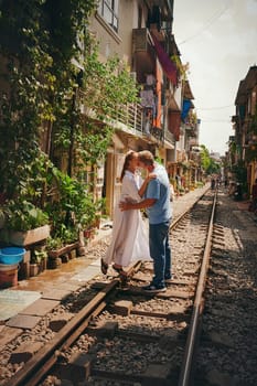 Nothing more romantic than a spontaneous kiss. a happy couple sharing a romantic moment on the train tracks in the streets of Vietnam