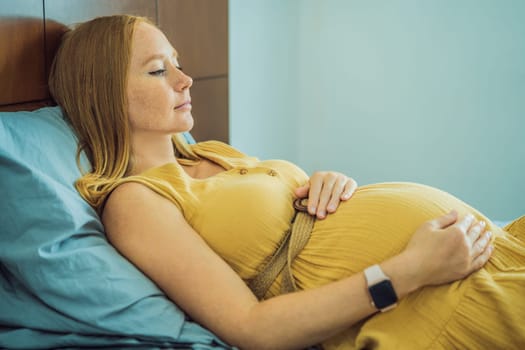 A stressed tired pregnant mother lying in bed at home. Morning sickness and nausea.