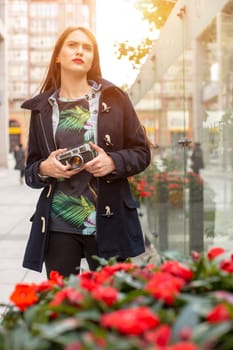 Portrait of a pretty young tourist taking photographs with vintage retro camera. Street style. Life style