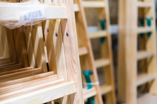 Many Wooden ladders. Stack of wooden stairs in the store.