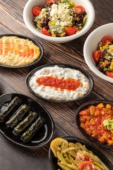 Mixed Turkish appetizers on wooden table. Turkish Mezze. such as stuffed leaves, humus