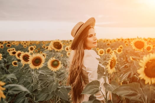 Woman in the sunflowers field. Summer time. Young beautiful woman standing in sunflower field.