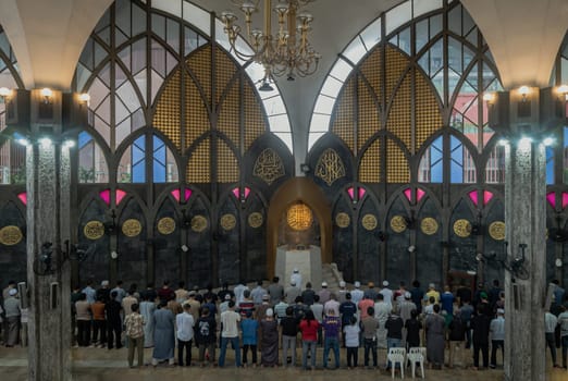 Bangkok, Thailand - May 28, 2023 - The Imam is the leader of the prayer, Religious muslim men praying for God on the floor in the Central Mosque and Islamic Center of Thailand. The religion of islam, Space for text, Selective focus.
