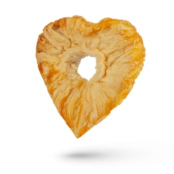 Dried piece of pineapple on a white isolated background. Dried heart shaped pineapple with empty center. Pineapple in the form of a heart hanging or falling. To be inserted into a design or project