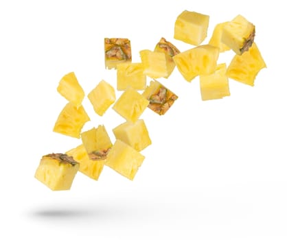 Pieces of pineapple on a white isolated background. Juicy pieces of pineapple with the remnants of the peel scatter in different directions. Isolate of flying pieces of pineapple