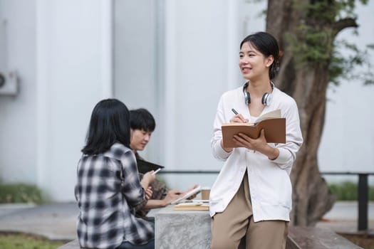 Students asian portrait together smiling group reading book study with laptop at university high school campus,college in summer holiday relaxation..