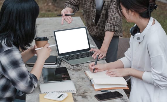 Group of Student working on laptop and record in book together at university. Happy friend successfully completes the thesis report and passed the final exam in asian college...