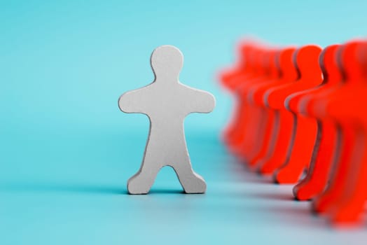 A white human figure stands out from the crowd of red figures. Talented and skillful suitable candidate. Initiative and active person, leader. Best choice of all. Concept of search for worker