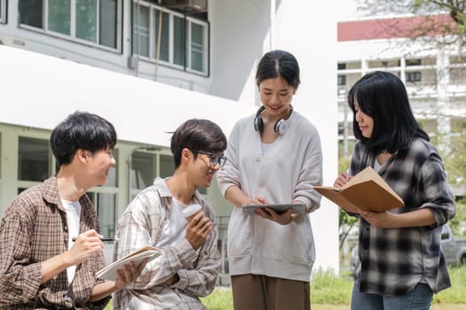 Group of Asian college student reading books and tutoring special class for exam on grass field at outdoors. Happiness and Education learning concept. Back to school concept. Teen and people theme...