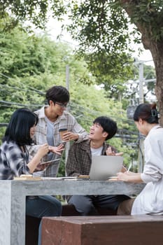 Group of Asian college student reading books and tutoring special class for exam on grass field at outdoors. Happiness and Education learning concept. Back to school concept. Teen and people theme...