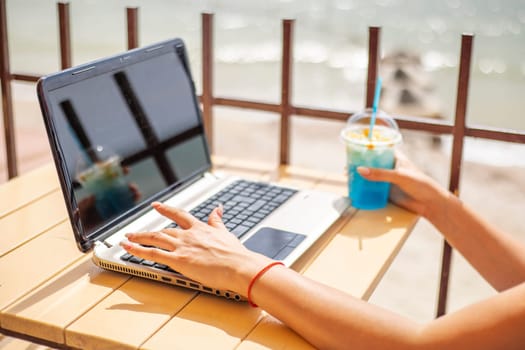 Young woman using a laptop computer. Woman working on laptop in an outdoor cafe.