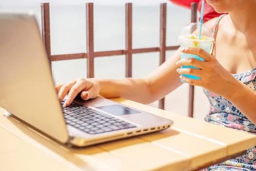 A woman working on laptop at wooden table. Woman working on laptop in a cafe.