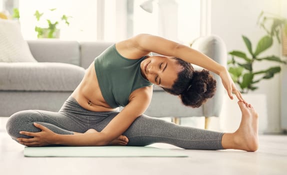 Yoga, stretching and woman on a living room floor for training, exercise or mental health at home. Leg, stretch and female with flexible fitness or pilates workout for balance, meditation or wellness.