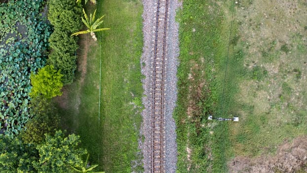 Aerial view of the railway in the park. Top view of the railroad from a drone. Train tracks in rural scene