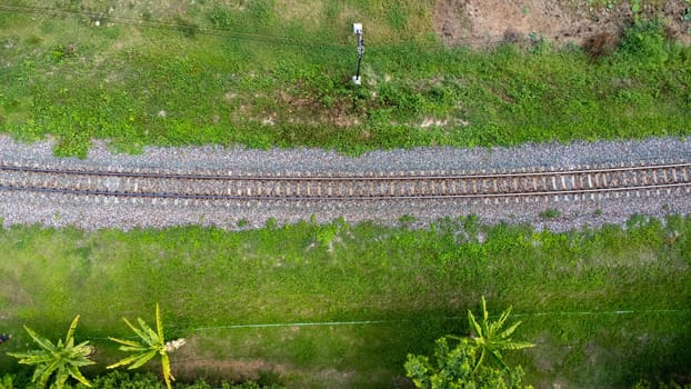 Aerial view of the railway in the park. Top view of the railroad from a drone. Train tracks in rural scene