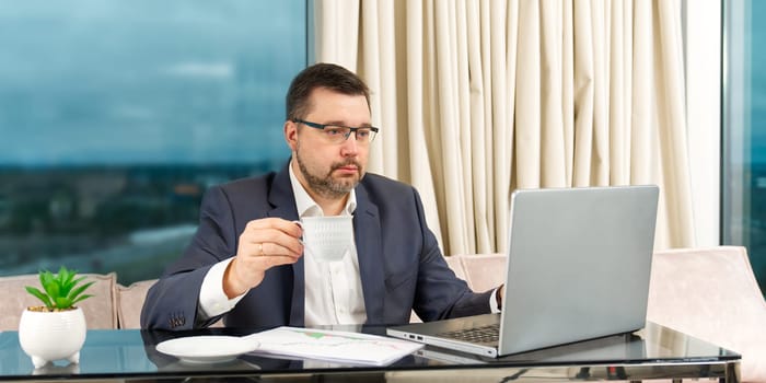 Happy businessman working on laptop in home office. financial investor working in the office. Accountant working on consolidated financial report of corporate operations.