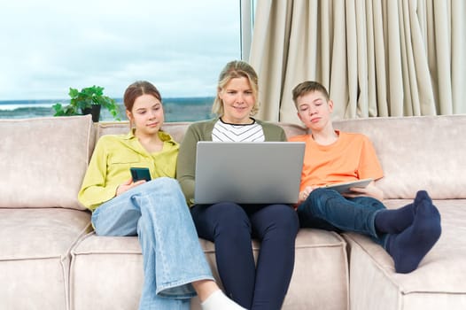 Happy Family on couch using gadget. Watching something online on computer together with family. Rest at home.