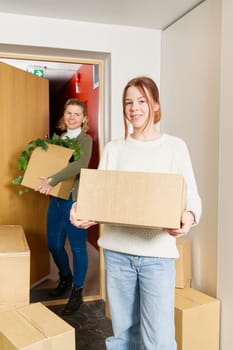 happy single mother with childrens moves to a new house. Moving day concept. children carry cardboard boxes when moving.