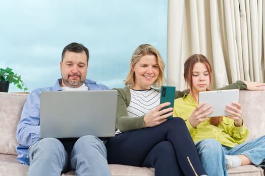 Happy Family on couch using gadget. Watching something online on computer together with family. Rest at home.