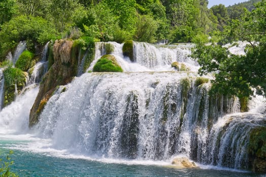 Beautiful Waterfall background in sunny summer day. Beautiful Waterfall In Krka National Park - Croatia, Europe. Krka river waterfalls in the Krka National Park