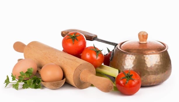 copper pan, rolling pin, spoons and different raw vegetables on a white background