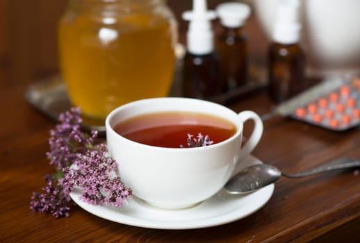 Still life from medicinal herbs, honey, herbal tea and medicines on a wooden background