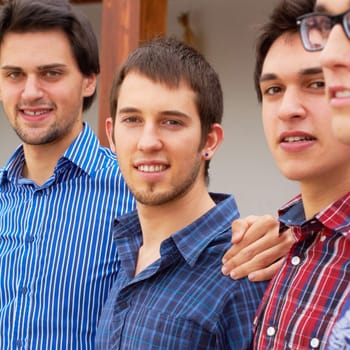 Group, men and portrait of brothers together standing in an outdoor garden by their house. Happy, smile and male people or friends in casual outfit standing with embrace in the backyard or nature