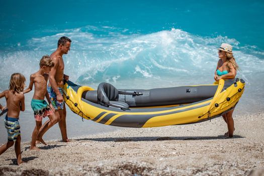 Happy family preparing rubber kayak for sailing at the beach. 