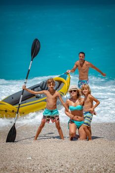 Happy family preparing rubber kayak for sailing at the beach. 