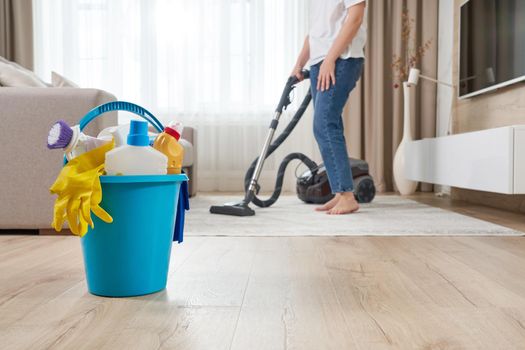 Woman cleaning the carpet with vacuum cleaner in the modern living room