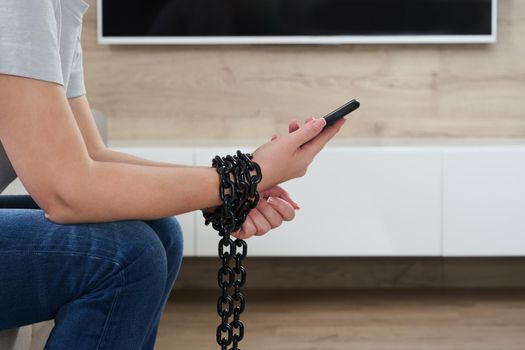 Close-Up Of Person Holding Mobile Phone And Chain