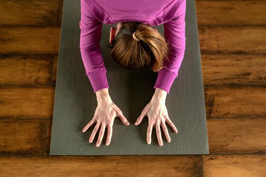 Portrait of a beautiful young woman sitting in yoga pose at the beach
