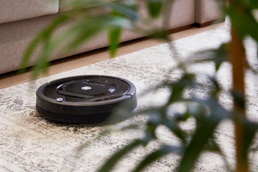 Robotic vacuum cleaner on carpet in cozy living room