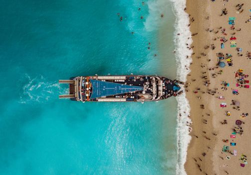 Aerial view of the tourist boat anchoring on the Egremni beach with turquoise colored sea water.  