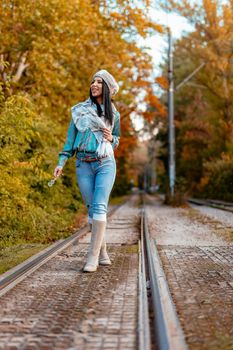 Beautiful young pensive woman enjoying in autumn colors  walking in the city park, looking away.