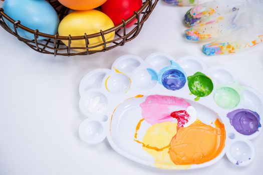 Design concept - Preparing for Easter celebration, painting Easter eggs with colorful Acrylic pigment color dyestuff in palette, top view, lifestyle.