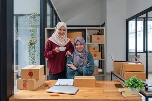 two muslim woman working online sales of they made at home. small business muslim selling online.