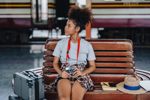 Asian teenage girl african american traveling using a camera take a photo to capture memories while waiting for a train at the station