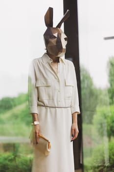 Fashionble woman in rabbit mask in the interior.