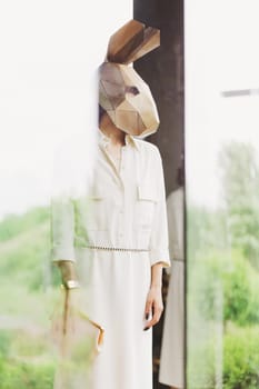 Fashionble woman in rabbit mask in the interior.