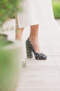 Close up of slim legs of woman wearing high heel shoes