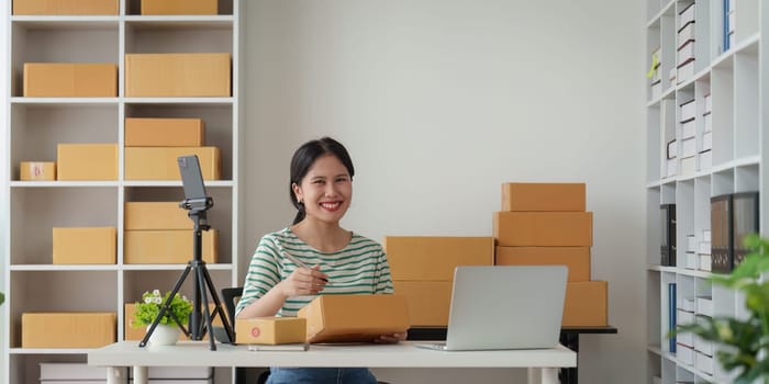 Businesswoman with Laptop and Parcel Box. A Symbol of SME Success in E-Commerce