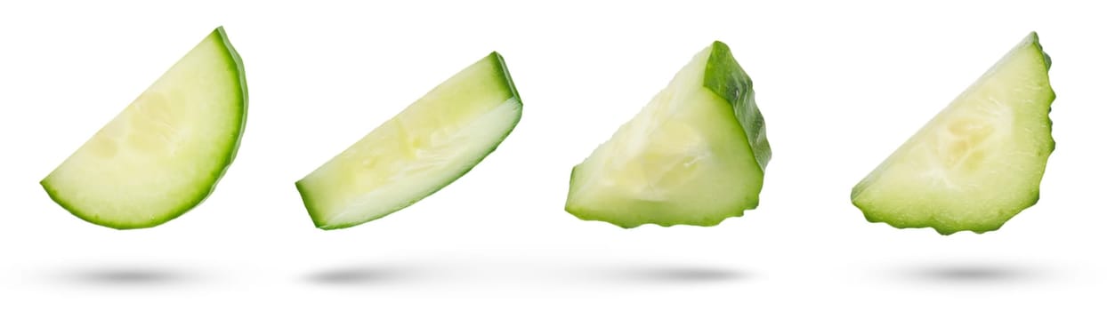 Slices of green cucumbers on a white isolated background. Cucumber slices hanging or falling on white. The concept of a delicious addition to a salad. High quality photo