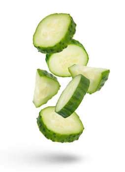 Slices of green cucumbers on a white isolated background. Slices of green cucumbers scatter in different directions. The concept of a delicious addition to a salad. High quality photo
