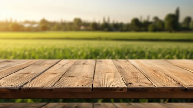 The empty wooden brown table top with blur background of farmland and blue sky. Exuberant image.