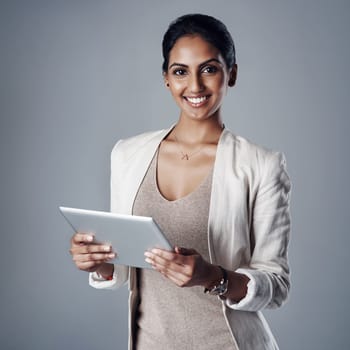 Technology, portrait of a woman with a tablet and against a studio background for social networking. Online communication or connectivity, happy and businesswoman reading or writing an email.